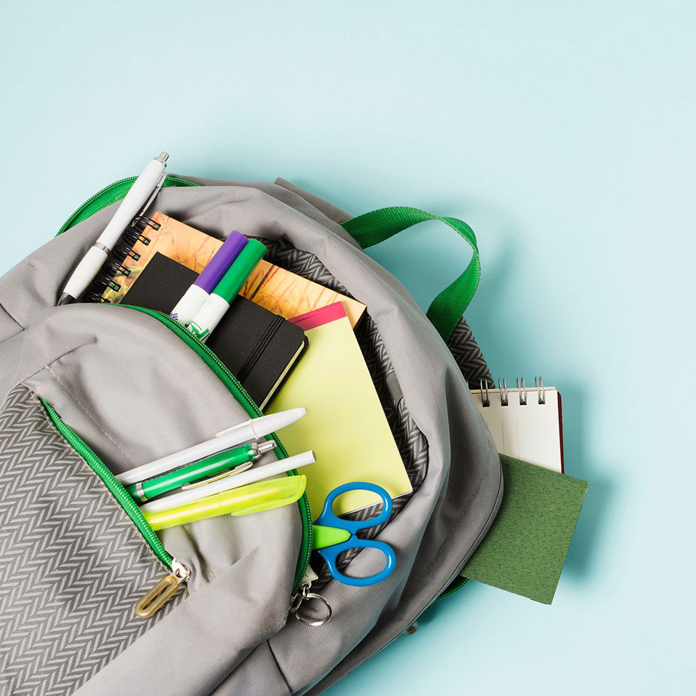 A grey backpack with all a students stationery on show