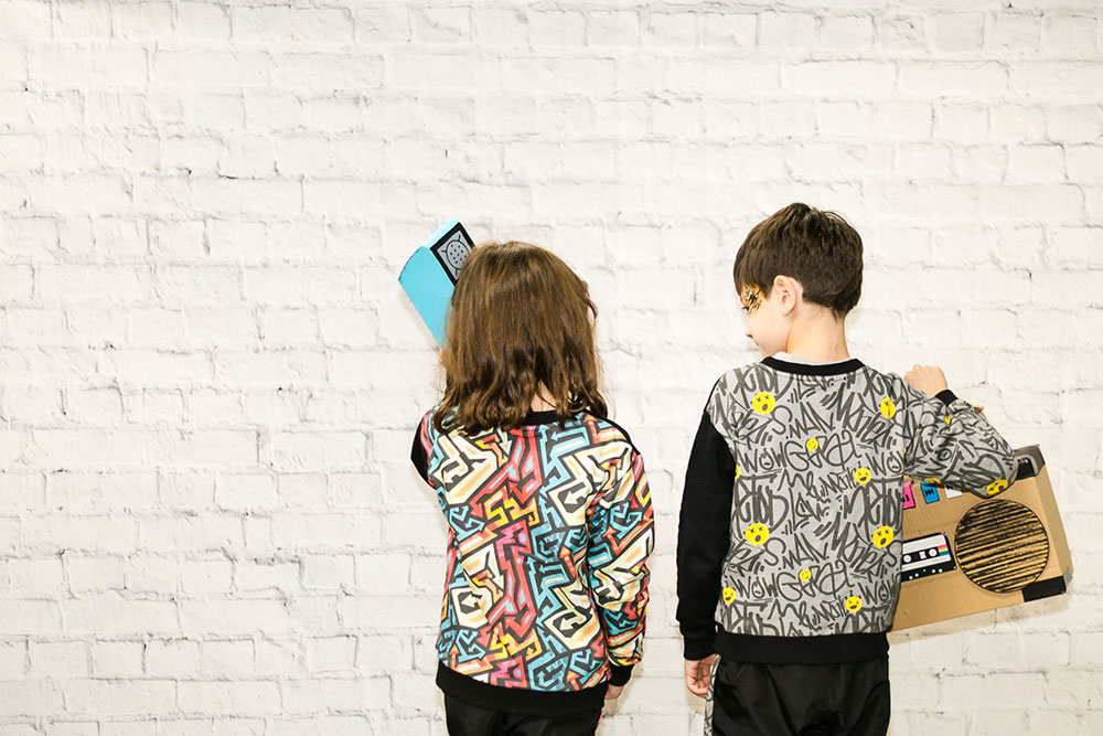 A boy and girl stood together facing the wall
