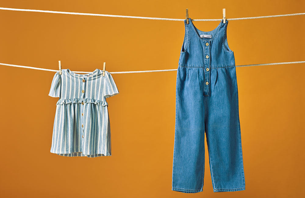 colourful kidwear by dotte haning on clothes line against dark yellow background