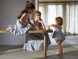 Woman and children beside a table wearing Newbie