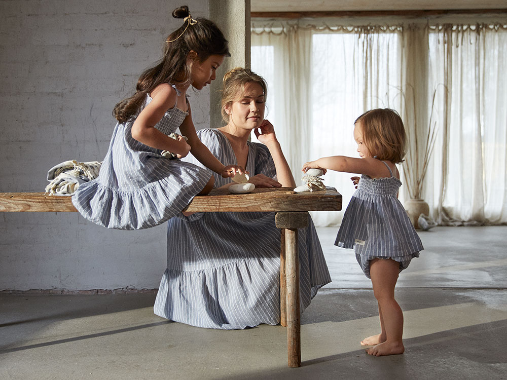 Woman and children beside a table wearing Newbie