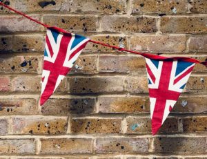 Union Jack bunting hanging in front of a brick wall
