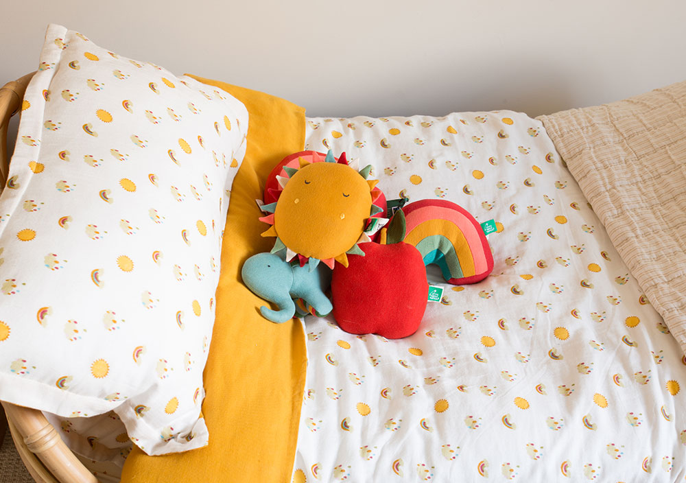 A pile of soft toys laid on a bed