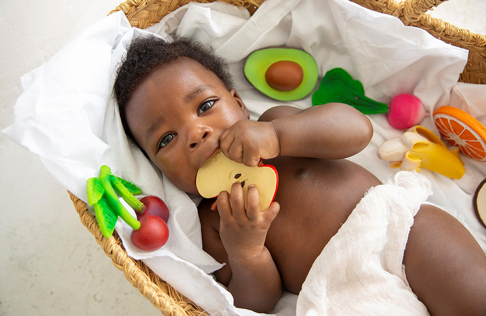 baby boy biting on Oli&Carol teething toy apple