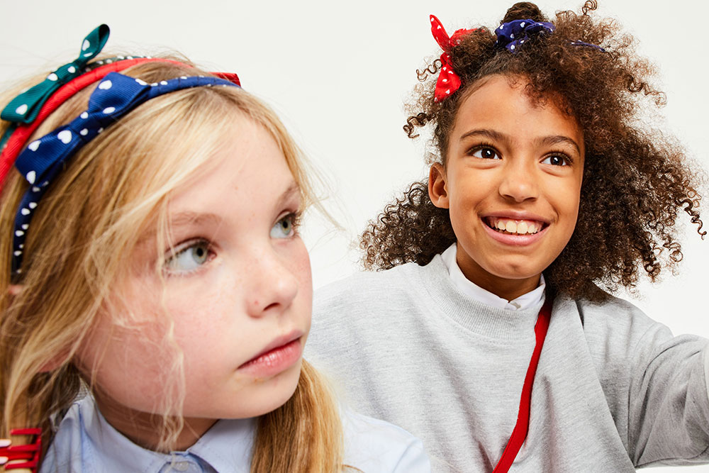 Two young girls wearing hair accessories