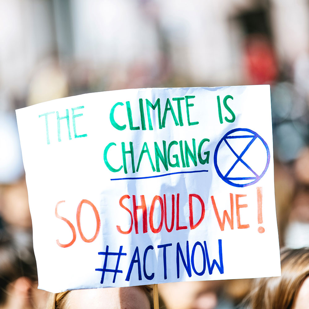 Hand written sign - The climate is changing. So should we!