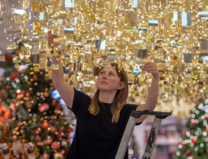 Woman hanging Christmas decorations in a John Lewis store