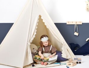 Girl sat in a tepee by The Little Green Sheep