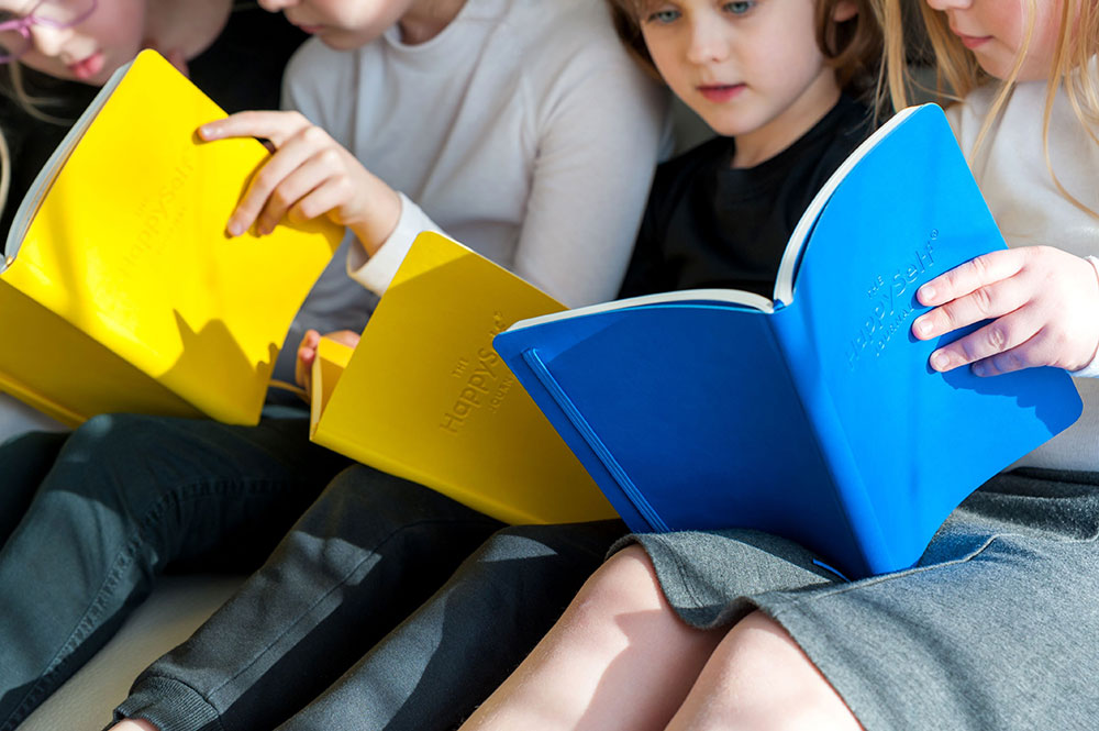 Four young girl's reading their journals