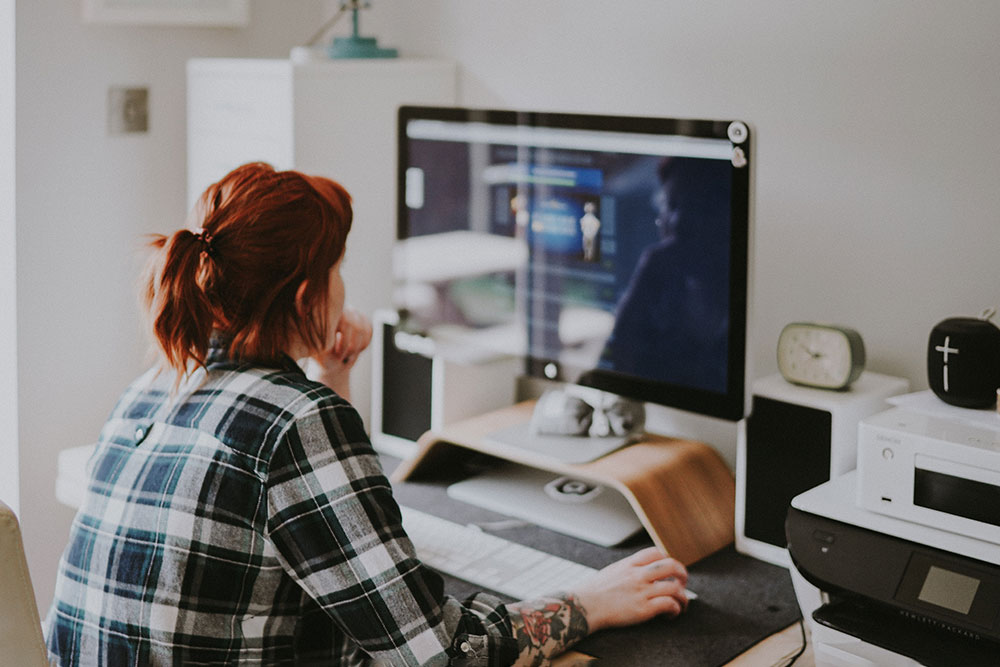 A woman with a tattoo on her arm sat working on a computer