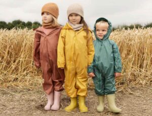 Three children stood in front of a corn field wearing Kidly Label
