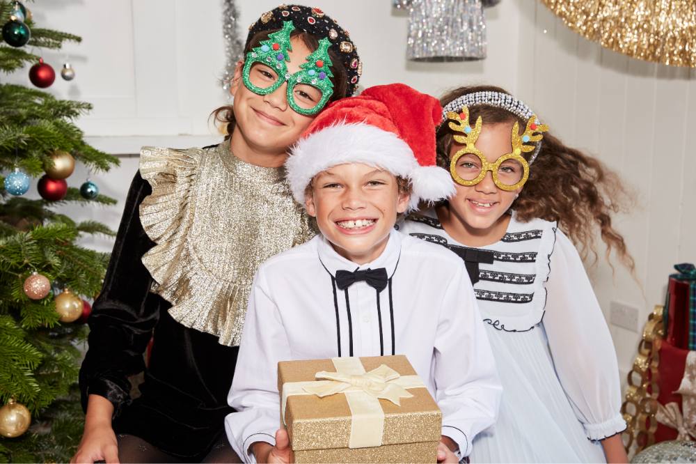 Three children dressed for Christmas