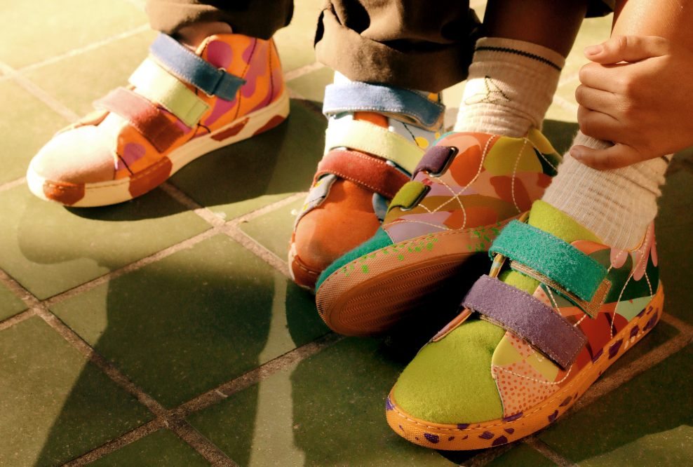 two children's feet wearing brightly coloured Dulis trainers 