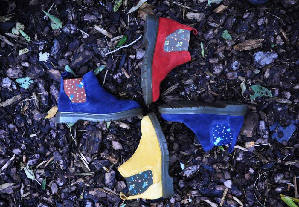 Four children's boots outside on leaves 