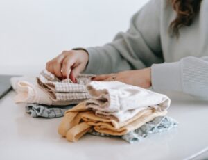 Woman folding baby clothes on a table