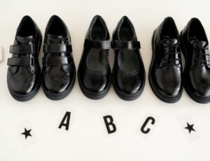 Black school shoes by TT Kids lined up on a white background with the letters A B C