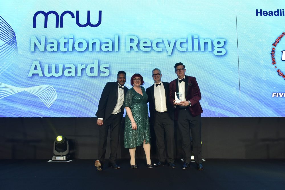 Four people stood on a stage receiving an award at the MRW’s National Recycling Awards