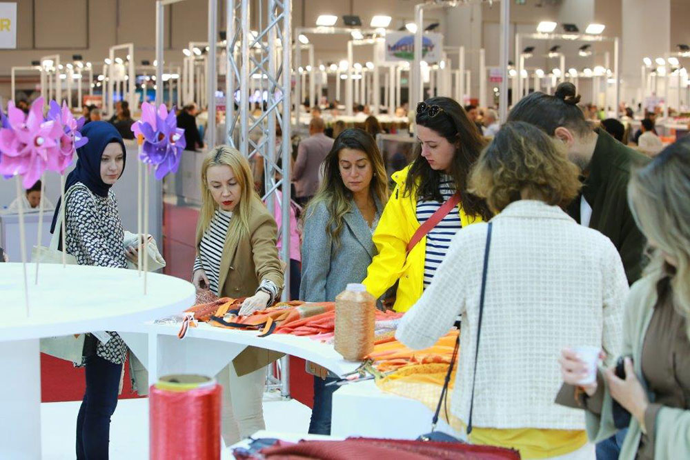 Visitors looking at fabrics on a stand at Texhibition