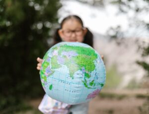 Young girl holding up an inflatable world globe