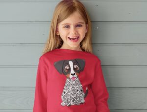Young girl stood against a grey panelled wall wearing a red top with a dog on the front from the Zuma the Dog AR range