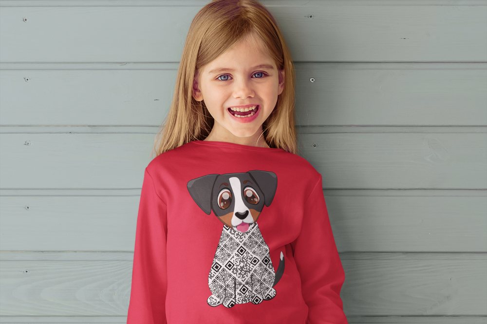 Young girl stood against a grey panelled wall wearing a red top with a dog on the front from the Zuma the Dog AR range