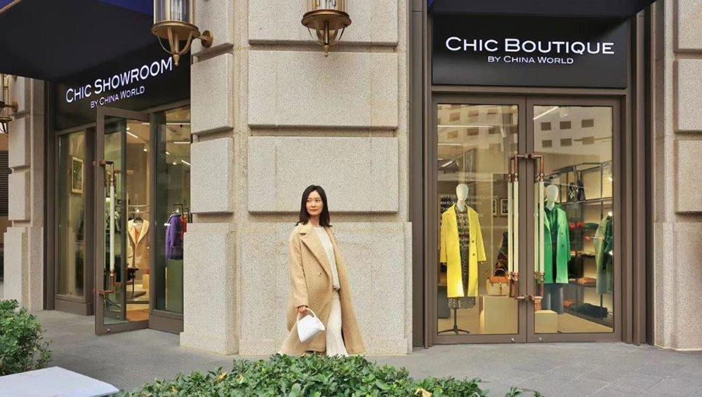 Woman walking outside the store front of Chic Boutique