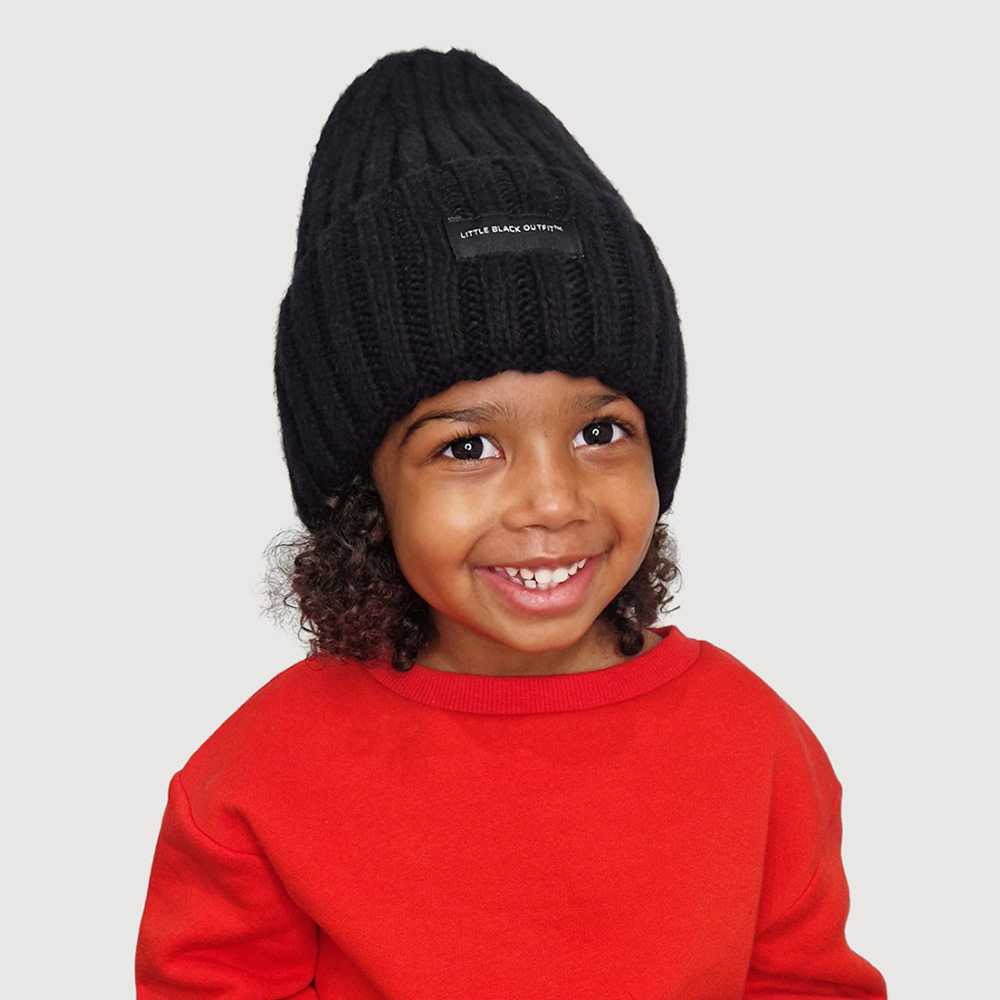 Boy wearing a bright red jumper and black beanie hat