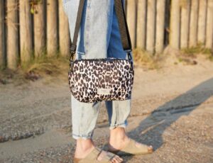 Woman stood outside with a leopard print Finnson changing bag on her shoulder