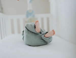 A Baby lying on their back in a crib