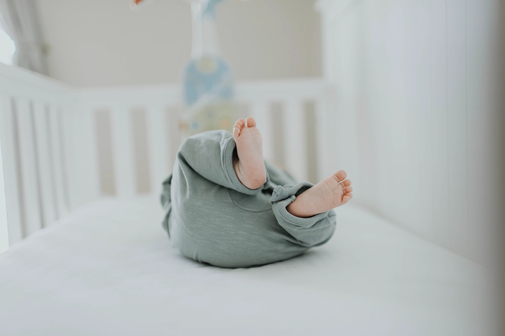 A Baby lying on their back in a crib