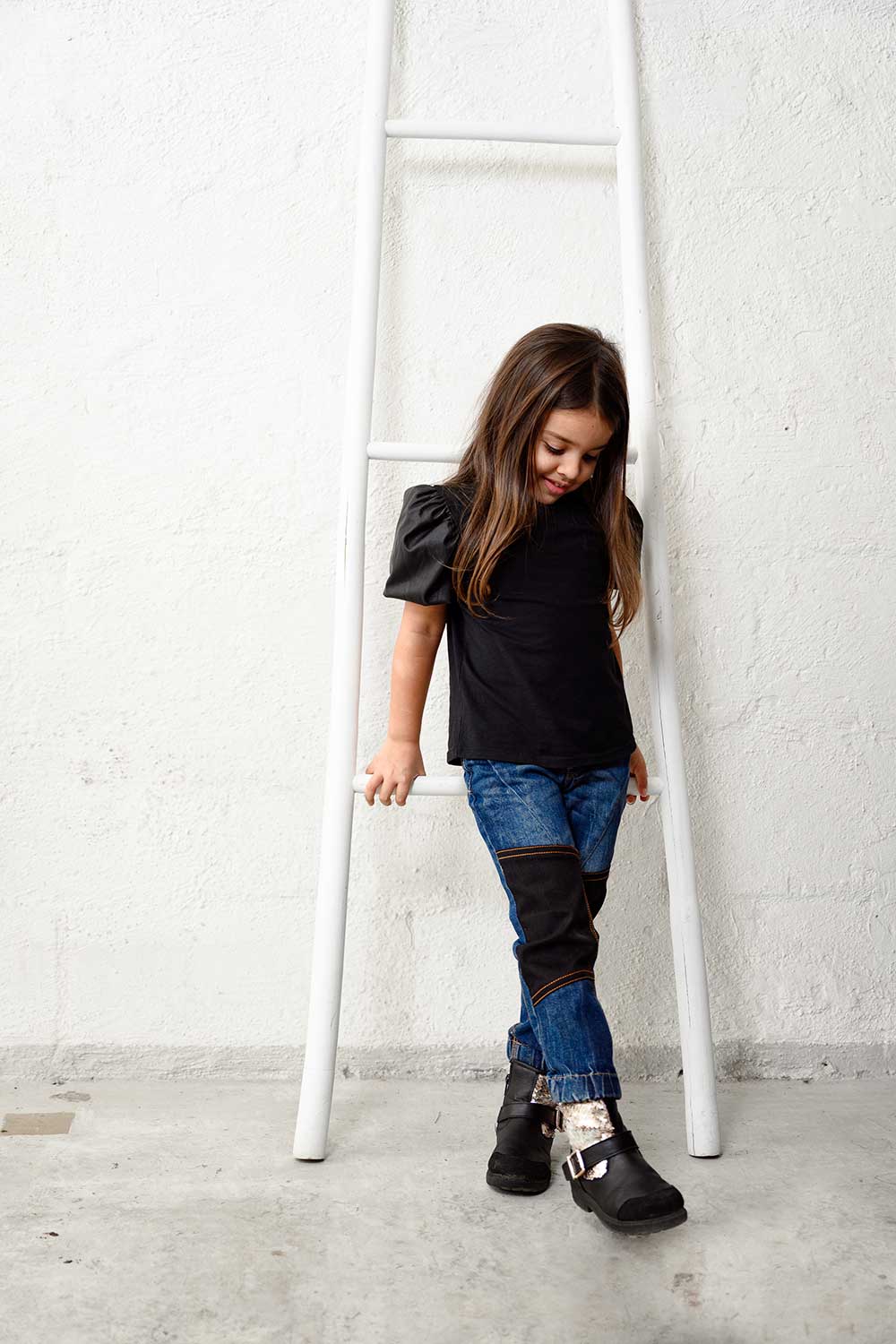 Girl stood next to a wooden ladder