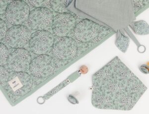 Flat lay of textile baby products from the BIBS x Liberty collection