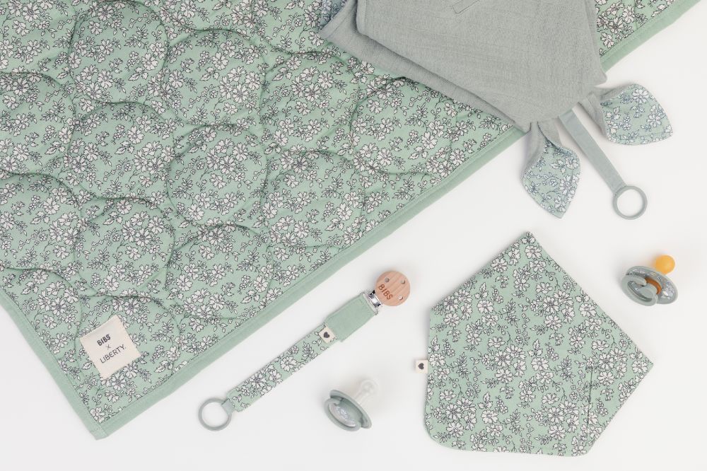 Flat lay of textile baby products from the BIBS x Liberty collection