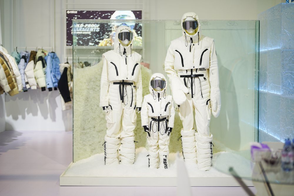 Mannequins on a stand at the CHIC trade show wearing white ski outfits