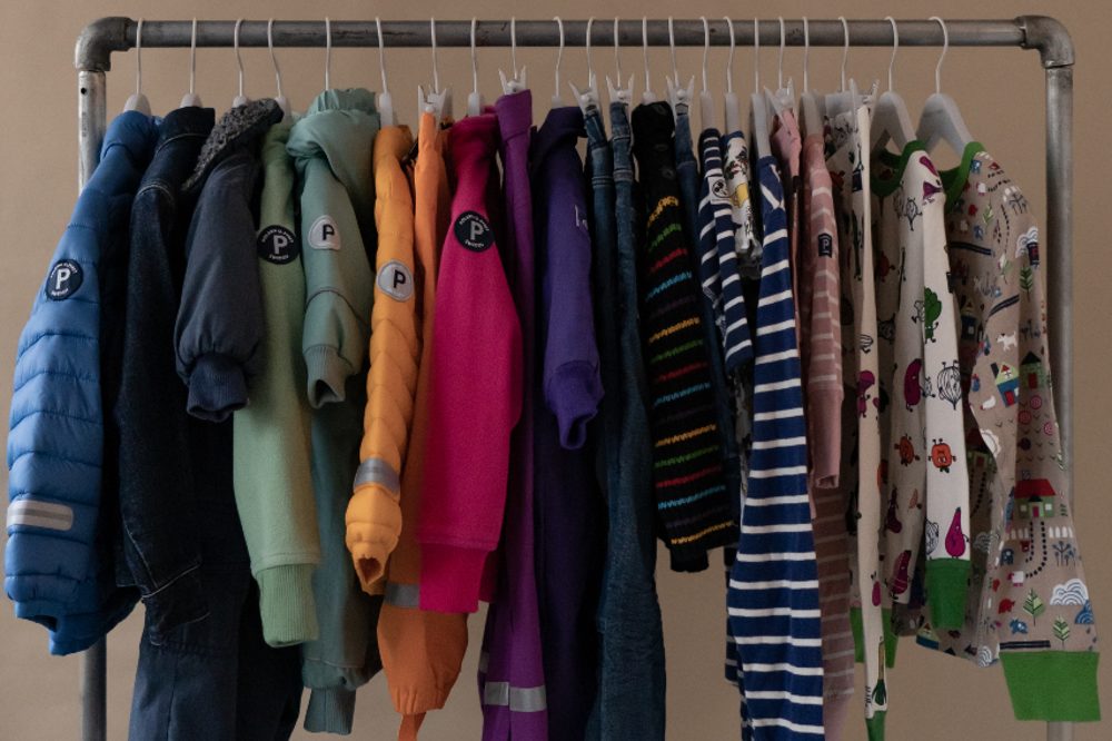 Children's clothes from PO.P Second-Hand hung on a metal clothes rail