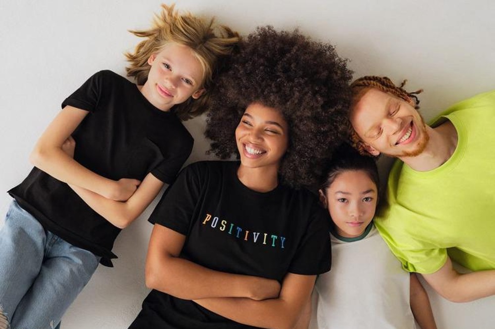 a woman and three young children lying down looking upwards wearing the new circular collection by Primark