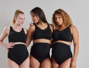 Three women stood wearing black maternity shapewear by Secret Saviours