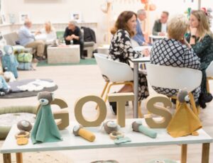 People sat on an exhibitor's stand at Kind + Jugend