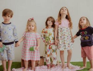 A group of children stood on artificial grass wearing Lilly + Sid clothing