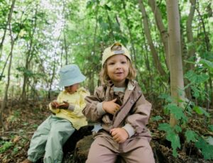 Two young children sat in a wood