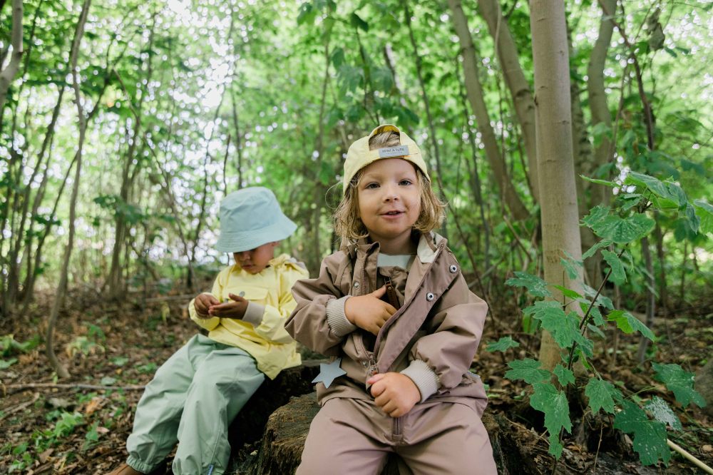 Two young children sat in a wood