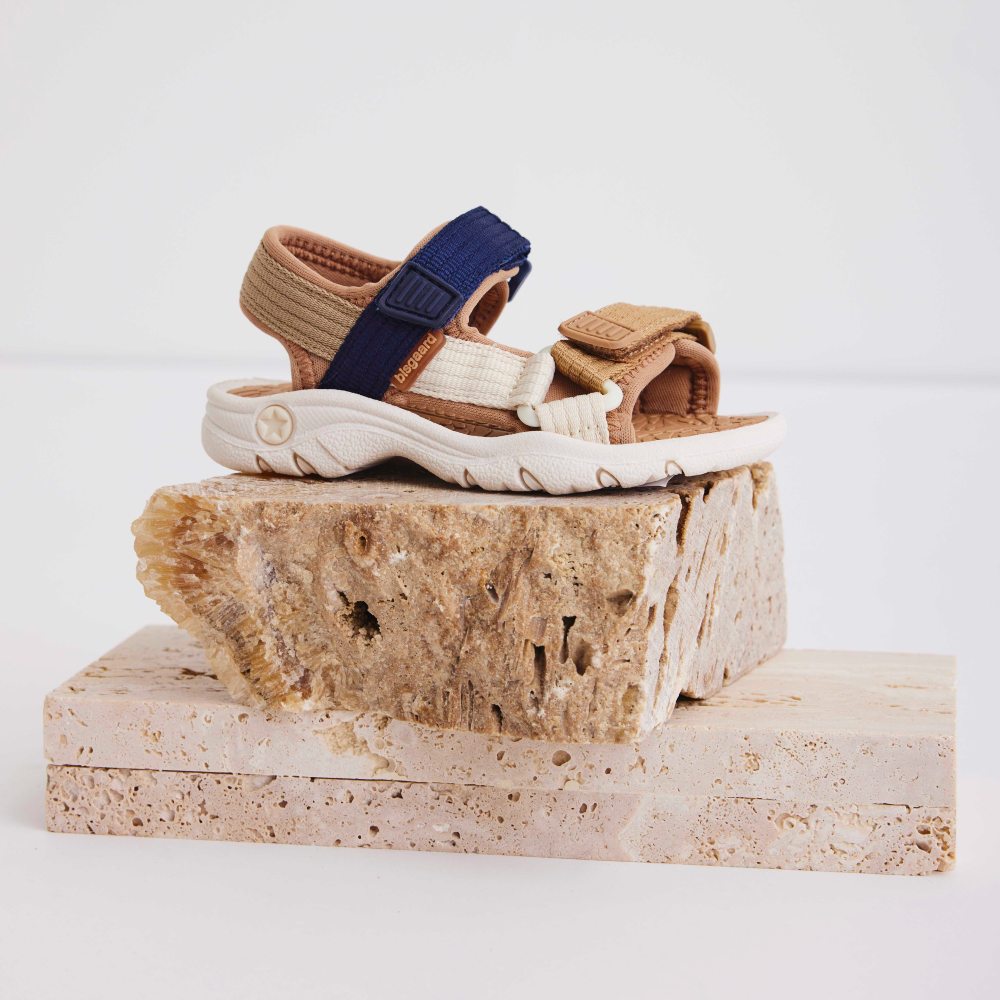 Child's Bisgaard sandal displayed on a block of wood 