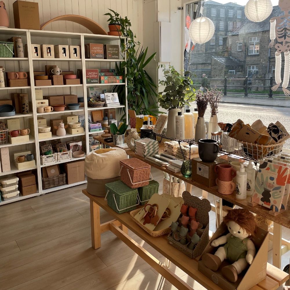Shop interior with shelves and a display table featuring kids' accessories and toys 