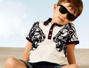 Young boy sat on the floor crossed legged wearing sunglasses