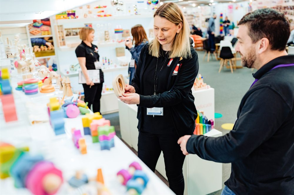 Two people stood at a trade show stand displaying toys