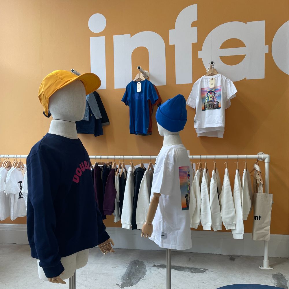 A shop with children's clothes displayed on a rail and mannequins 