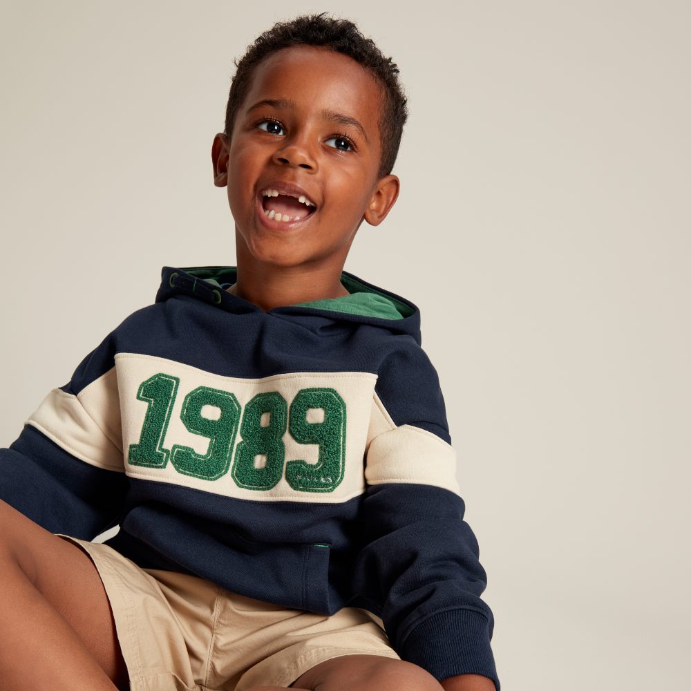 Young boy wearing a sweatshirt with 1989 on the front 