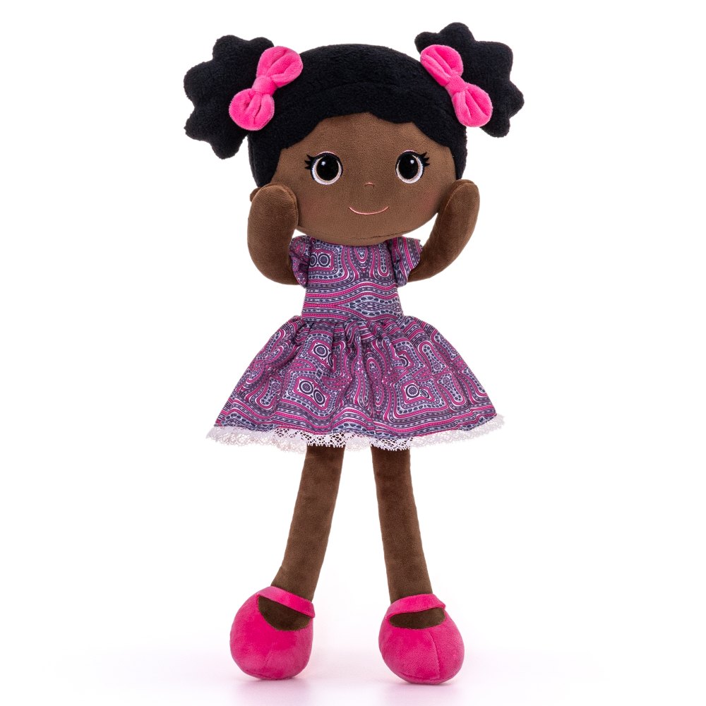 Brown skinned children's soft doll wearing a purple dress and pink hair bows and shoes 