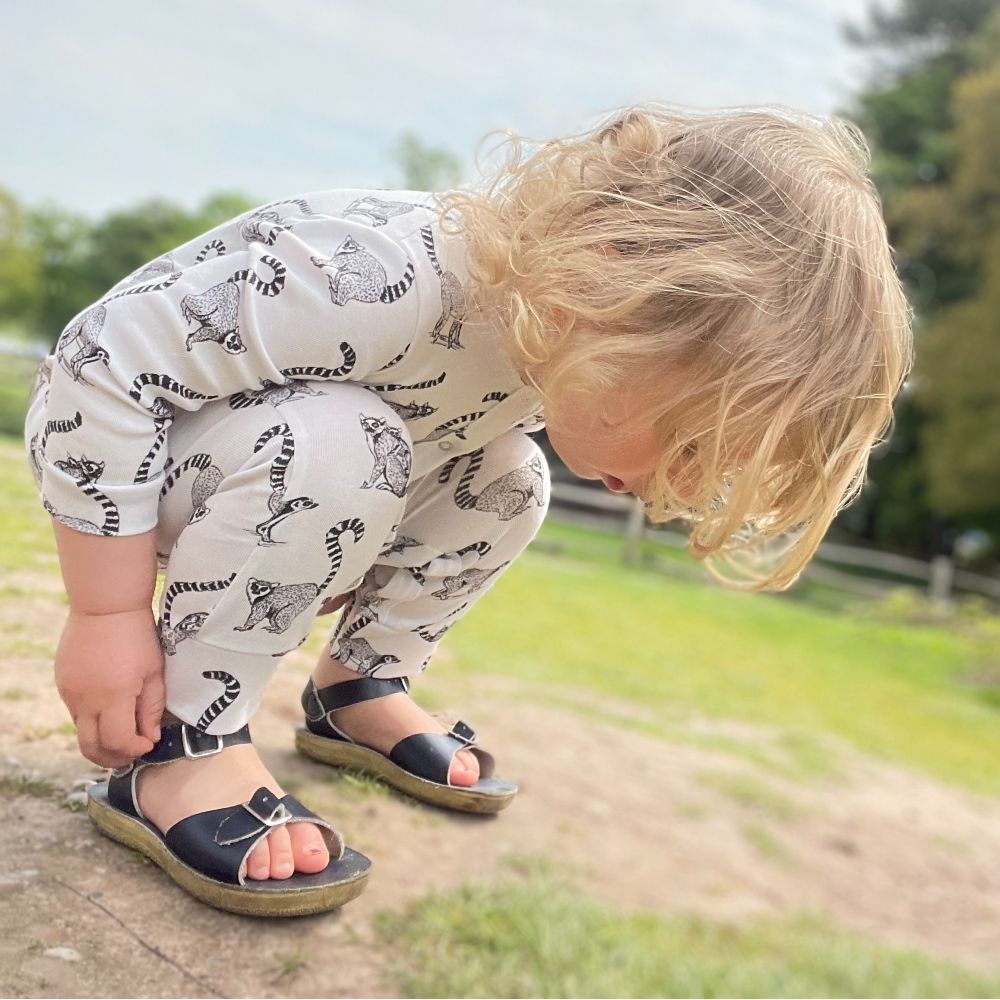 Young child crouched down on a rock 