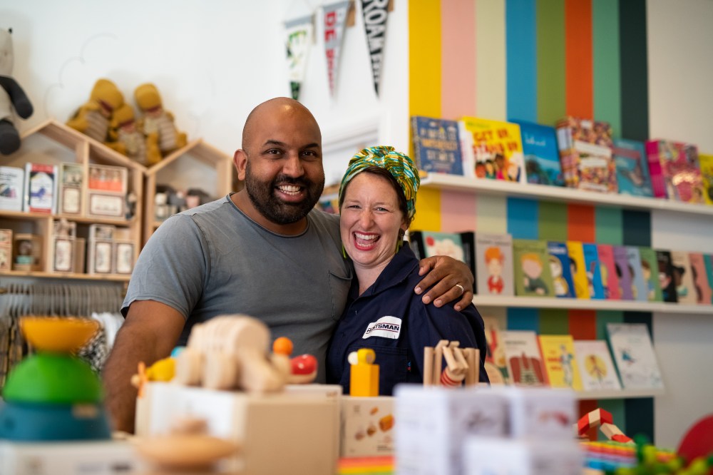 Couple stood with their arms around each other in a children's shop as part of Small Biz 100